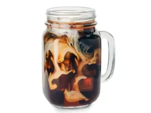 Coldbrew kava z mlekom in ledom v trendovskem kozarcu z ročajem na belem ozadju.