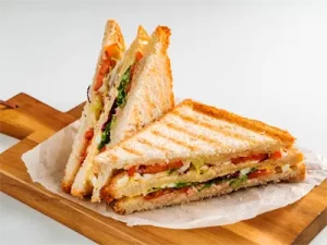 Trojni toast next, na peki papirju na lesenem podstavku